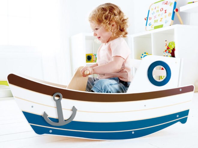 child playing in a small wood boat