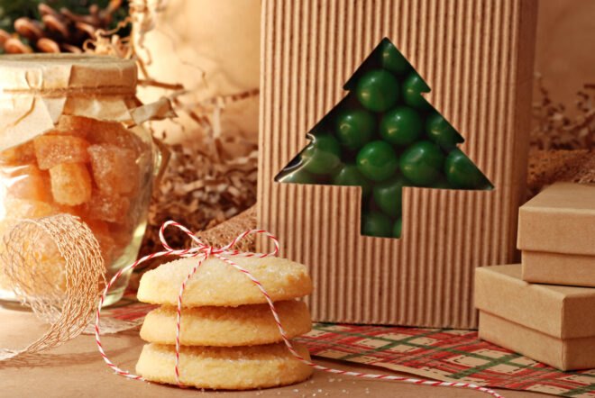 green candy in cardboard package, orange candy in glass jar and sugar cookies tied in string
