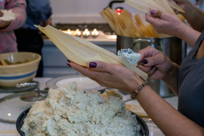 family in kitchen making tamales