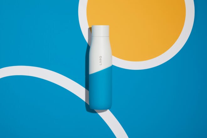 white and blue water bottle on blue and yellow background