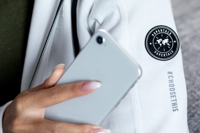 person using phone to scan a tag on their white sweatshirt