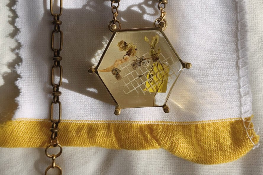 discarded trash encased in resin in a necklace