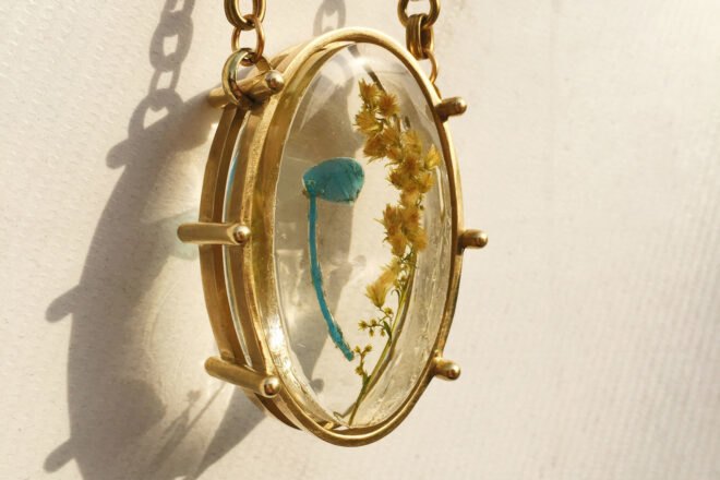 trash inside resin in a gold pendant