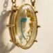 trash inside resin in a gold pendant