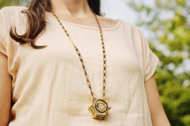 person wearing long gold necklace
