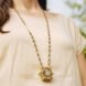 person wearing long gold necklace