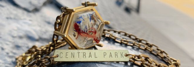 gold pendant made out of trash with gold tag that reads, "Central Park"