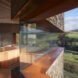 side view of stone home with long, narrow glass panel in the living area