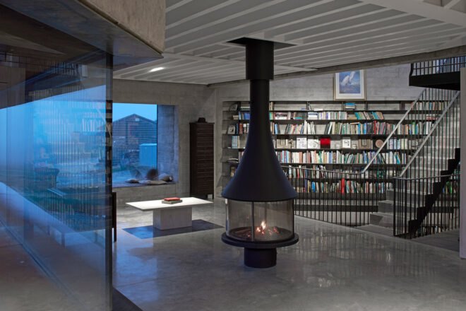 black fireplace in room with floor-to-ceiling bookshelves