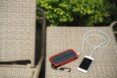 phone plugged in to solar-powered charger outside on patio furniture