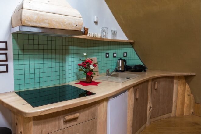 kitchen space with curved counter and teal backsplash
