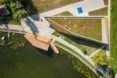 aerial view of green-roofed, triangular wood building near water