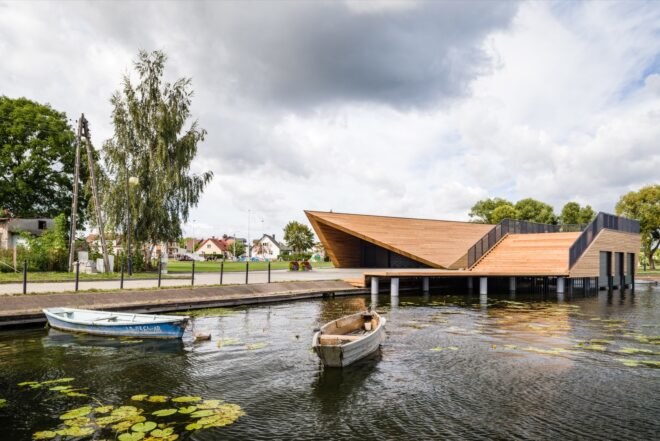 boat sailing toward wood building