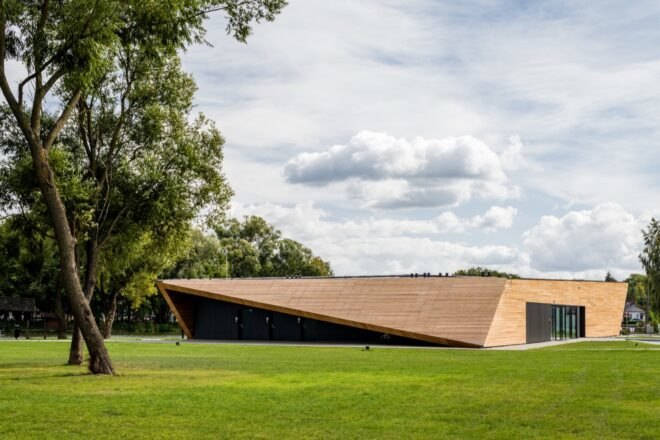sculptural wood building on grassy lot