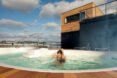 a woman in a hot tub on the deck of the Bota Bota structure