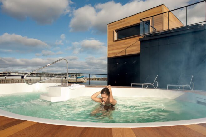 a woman in a hot tub on the deck of the Bota Bota structure
