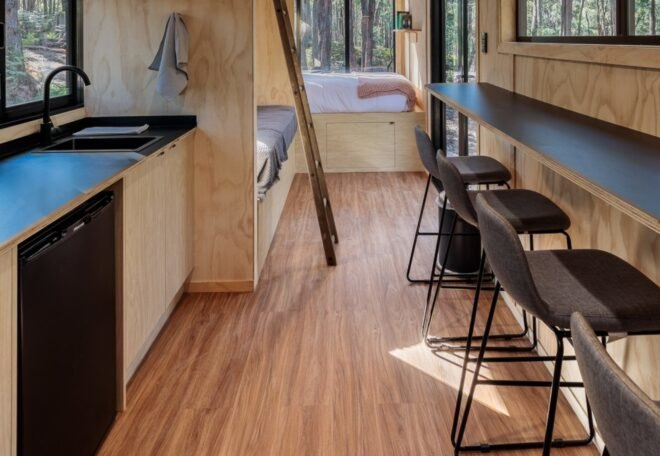 tiny cabin interior with light wood walls and floors and dark decor