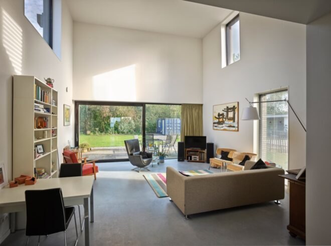 double-height white living room with beige sofa