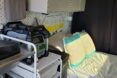 interior space of converted van, focusing on the head of the bed and a set of drawers with a power station stacked on top
