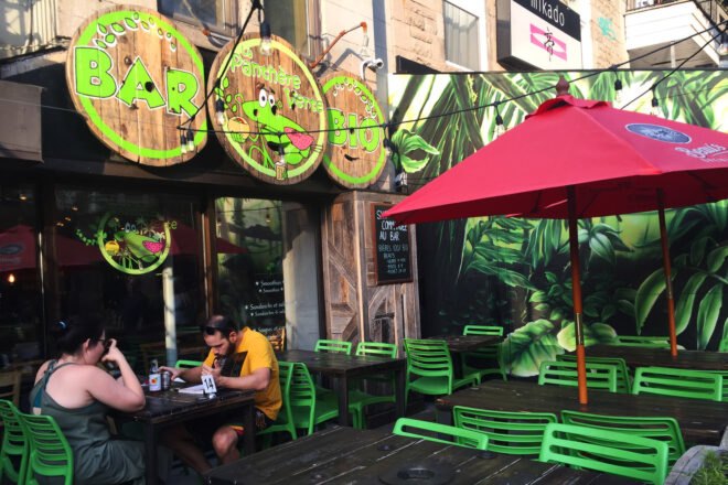 the exterior of a restaurant with three circular panels with green detail making the Green Panther logo signage