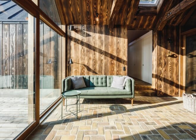 wood-lined living space with small, pale-green sofa