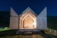 front of A-frame cabin with wood doors swung open