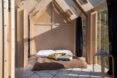 mattress and pillows on floor of small cabin