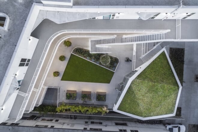 a birds-eye view of the housing project, showing several green spaces and white/gray walkways