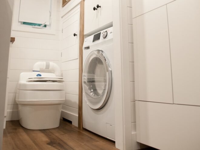 bathroom with composting toilet and washer and dryer combo