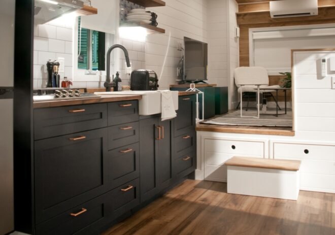 kitchen space with dark cabinets and wood counters