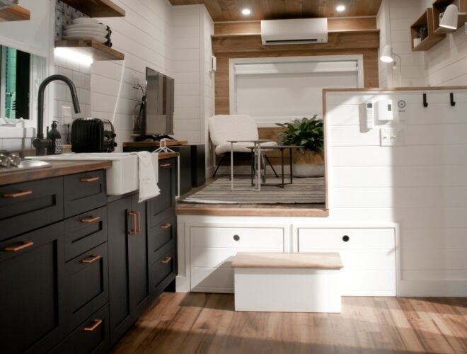 kitchen space inside tiny home with dark cabinets