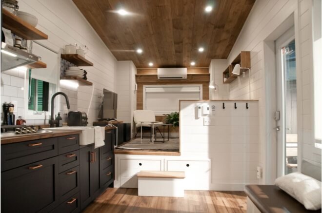 tiny home with white walls and a kitchen with black cabinetry