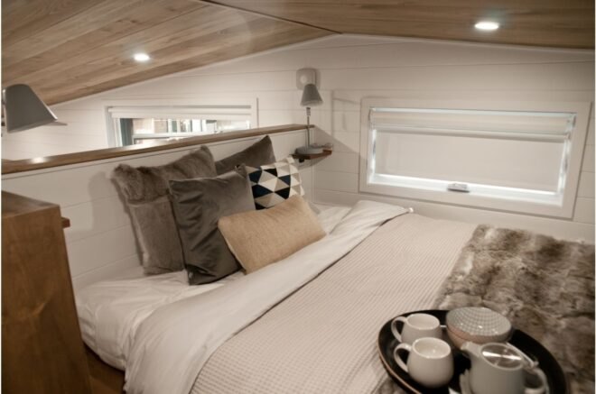 double bed with various pillows on a sleeping loft