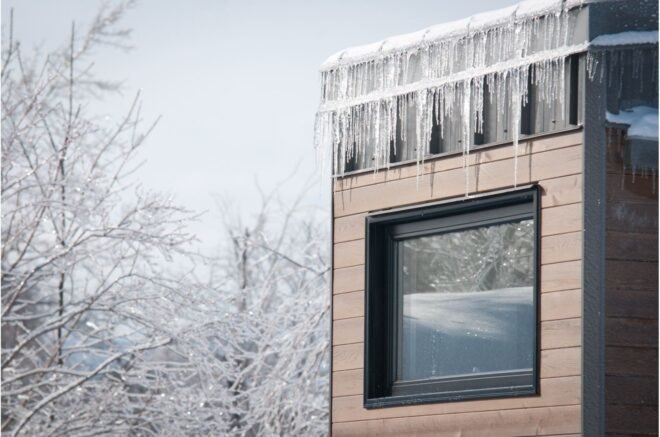 end of tiny home with large window covered in icicles