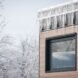 end of tiny home with large window covered in icicles