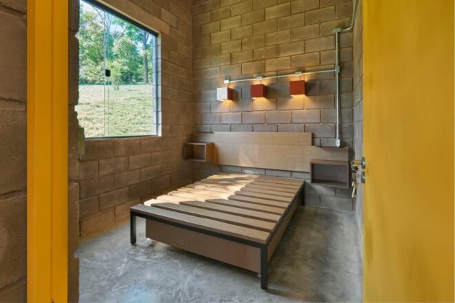 wood bed frame in brick-lined bedroom
