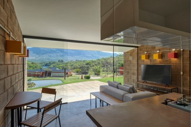 living area with small dining table, small gray sofa and a wall of glass