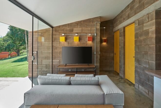wall-mounted television below yellow and orange square wall sconces