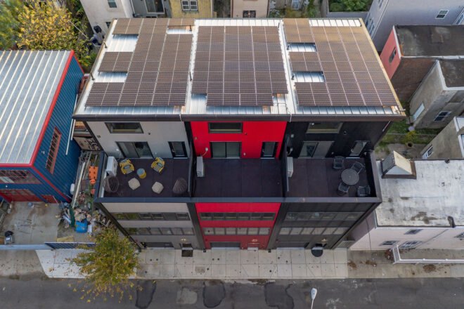 black, gray and red townhomes topped with solar panels