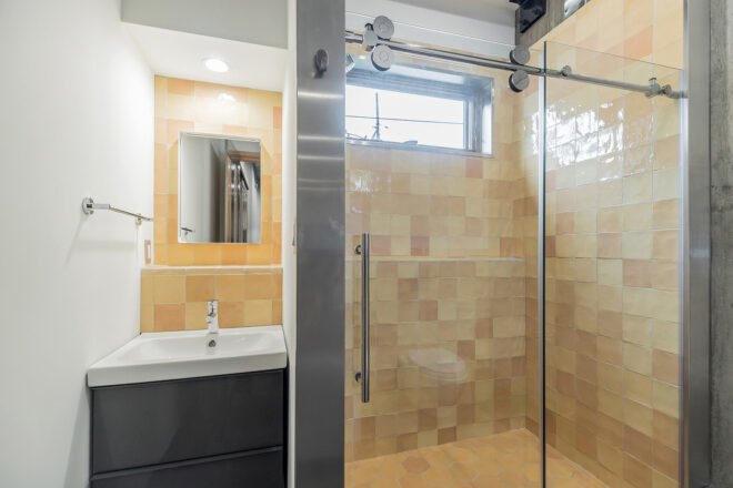 bathroom with tan-tiled shower stall