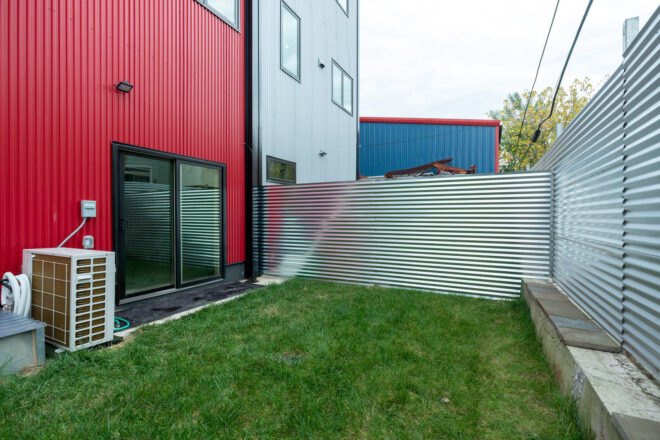 small green yard with corrugated metal fencing