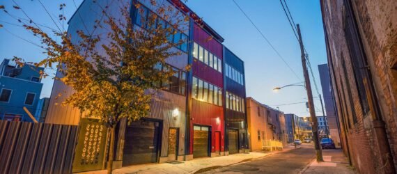 townhomes with gray, black and red exterior at dusk