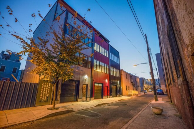townhomes with gray, black and red exterior at dusk