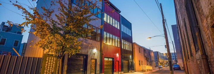 townhomes with gray, black and red exterior at dusk