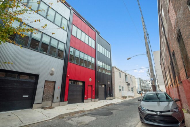 gray townhome beside a red townhome beside a black townhome