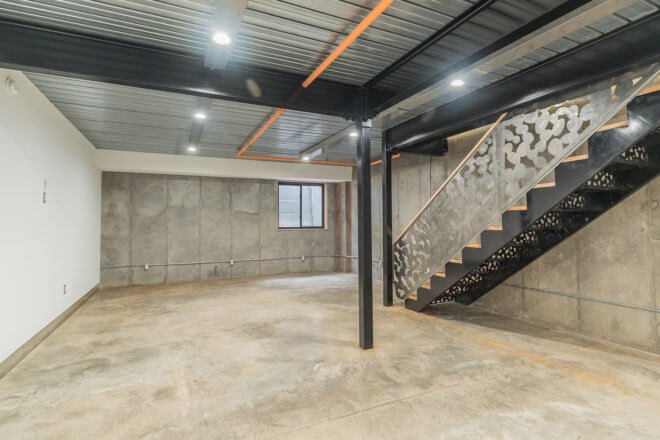 large gray room with black metal and wood staircase