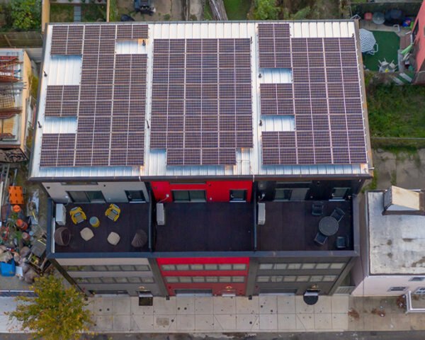black, gray and red townhomes topped with solar panels