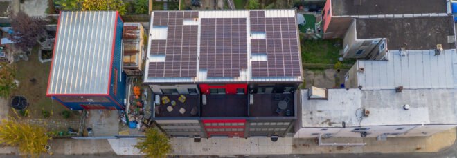 black, gray and red townhomes topped with solar panels