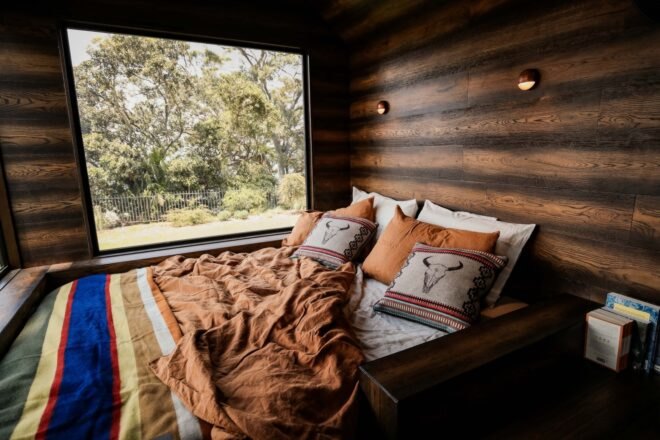 large bed with massive window in a cabin