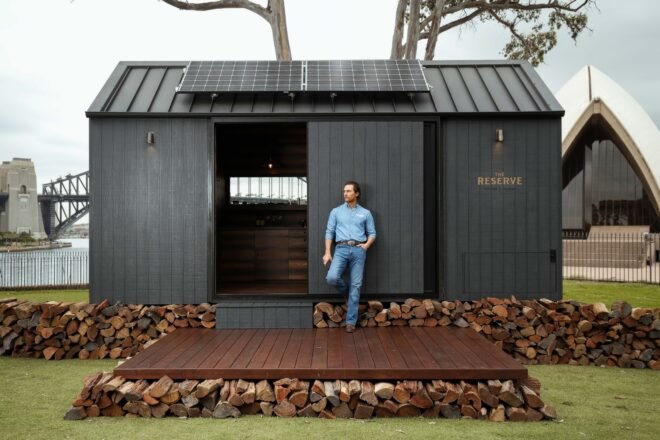 Matthew McConaughey standing in front of a dark tiny cabin